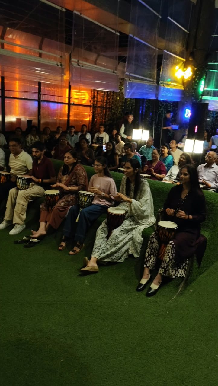 Group of people playing djembe drums together