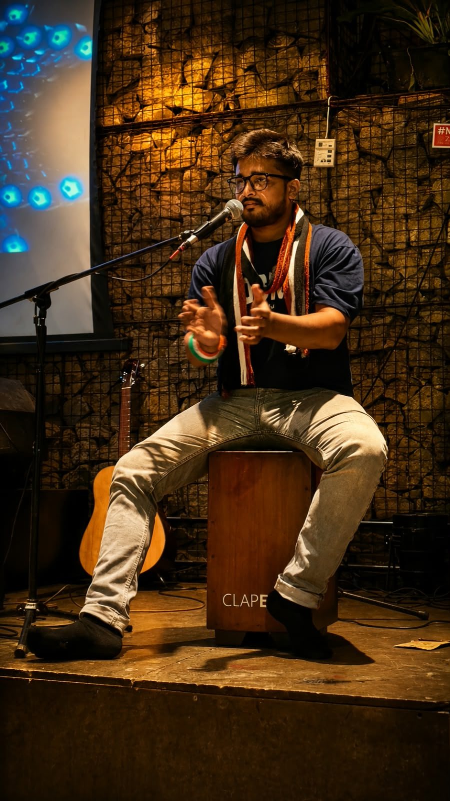 Facilitator clapping rhythm into a microphone on stage