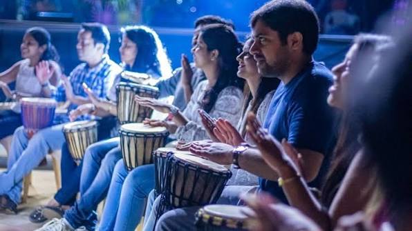 Facilitator clapping rhythm into a microphone on stage